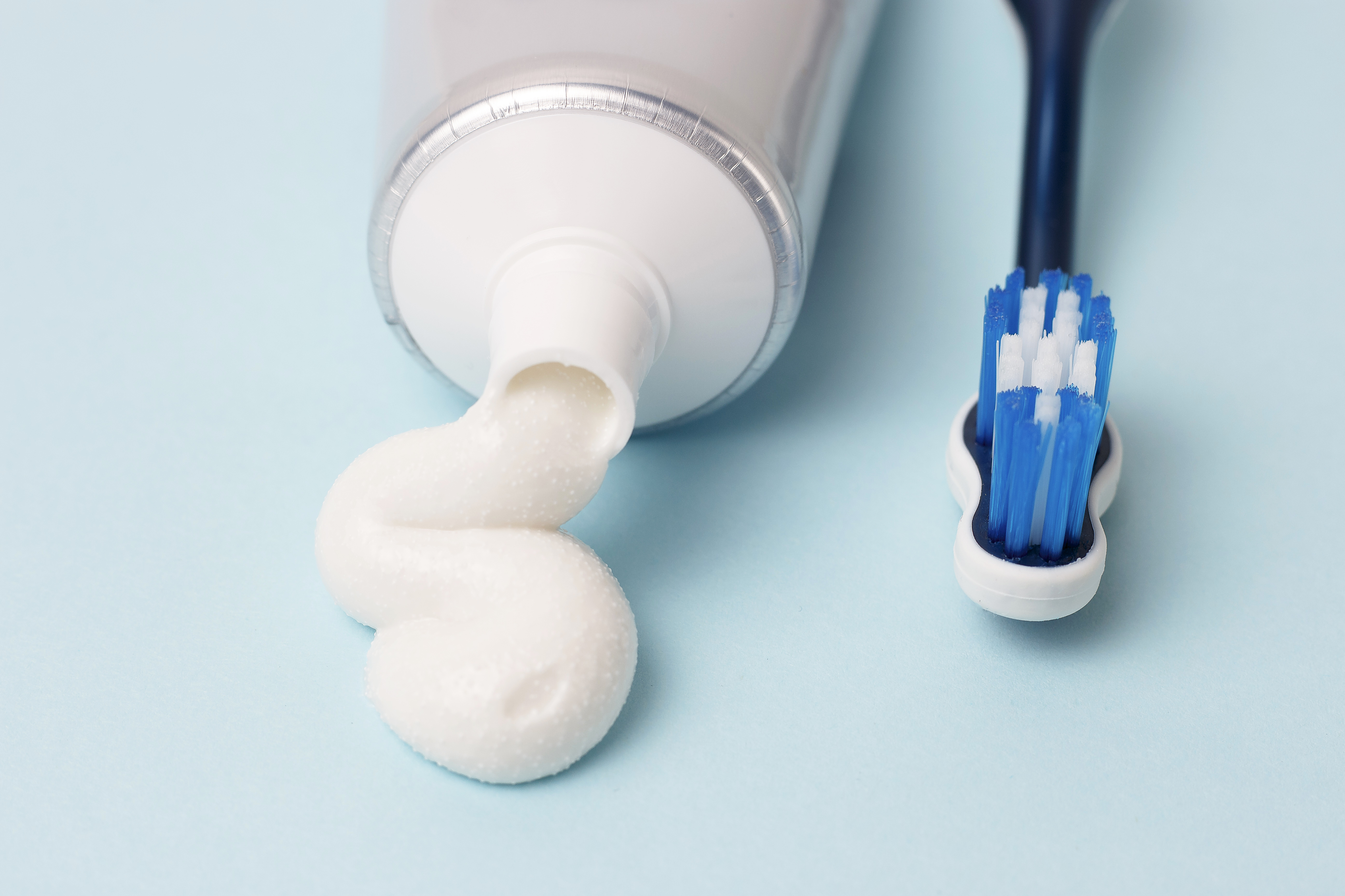 【牙齒Q&A】牙醫解答美白牙齒最常見的5個問題 5 toothpaste in tube and toothbrush on blue backgrou 2025 01 10 12 43 30 utc